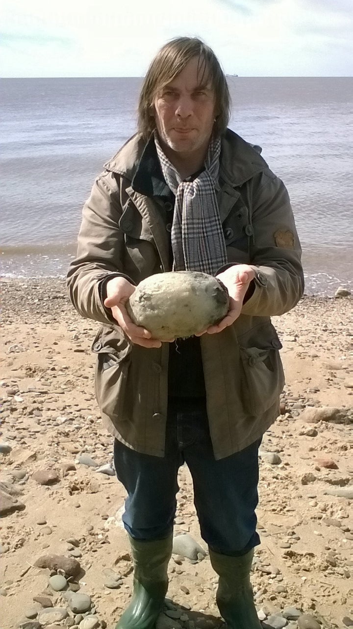 Gary Williams endures the stink of this whale vomit for a quick photo.