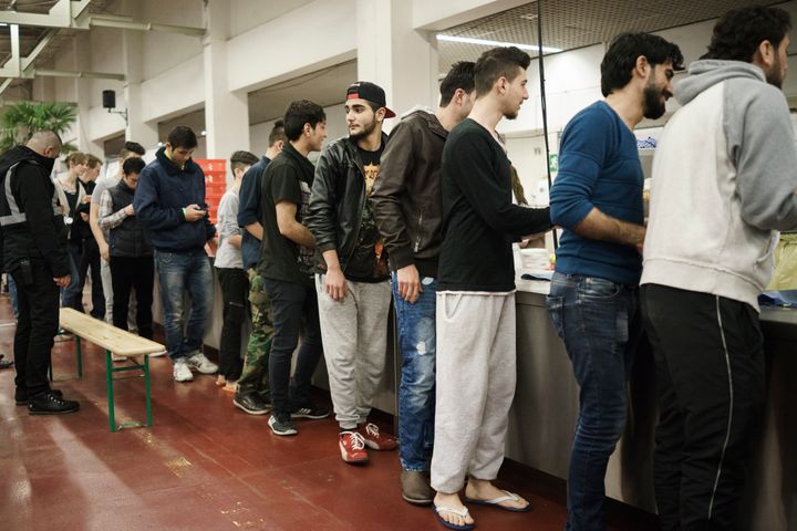 German citizen Alexa Best says that there is a reciprocal learning process between refugees and hosts. Refugees wait in line for food at a shelter in Berlin.