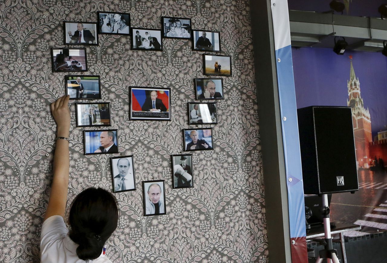A cafe dedicated to Russian President Vladimir Putin opened in Krasnoyarsk, Siberia, last month. An employee straightens photos of Putin arranged in the shape of a heart.