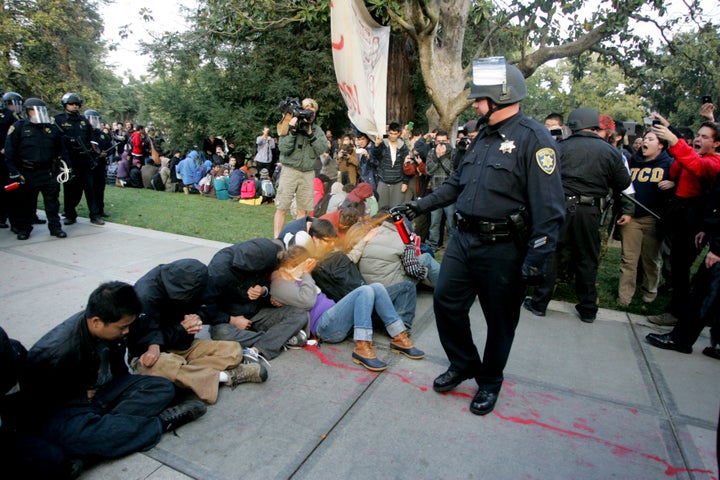 A University of California Davis police officer pepper-sprays students during their sit-in at an "Occupy UCD" demonstration in Davis, California, on Nov. 18, 2011.