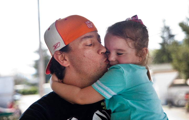 Bryan Thouvenel gives his daughter Harmony, 5, a kiss while standing for a portrait in front of their home in Myrtle Creek, Saturday, April 3, 2016.