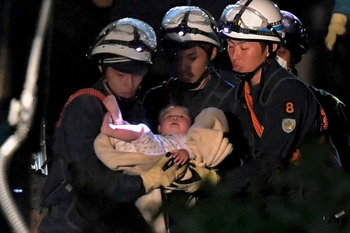 An eight-month-old baby is carried away by rescue workers after being rescued from her collapsed home caused by an earthquake in Mashiki town, Kumamoto prefecture, southern Japan, in this photo taken by Mainichi Shimbun April 15, 2016.