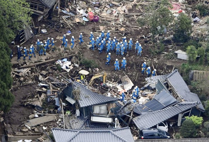 Rescue workers conduct a search and rescue operation in Minamiaso town. Dozens are thought to be trapped in collapsed buildings.
