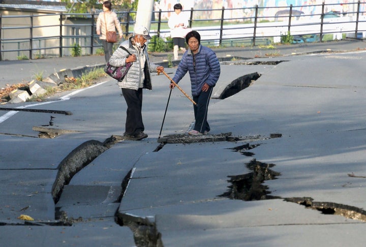 Local residents look at cracks caused by an earthquake on a road in Mashiki town. The USGS estimated that there was a 72 percent likelihood of the economic damage exceeding $10 billion.