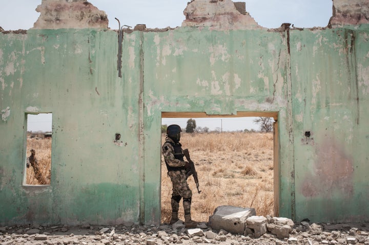 A Nigerian soldier stands amidst the ruins of the Government Girls Secondary School Chibok in Nigeria in March. Boko Haram kidnapped over 200 girls from the school two years ago.