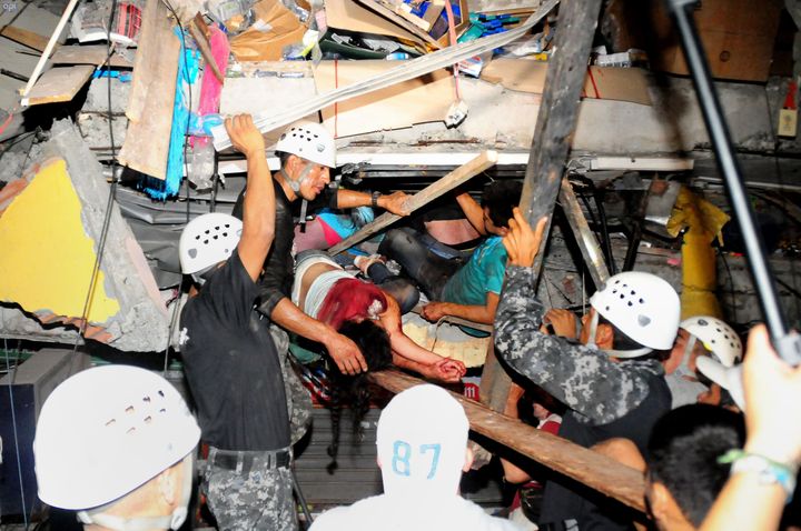 Rescue workers work to pull out survivors trapped in a collapsed building after a huge earthquake struck in the city of Manta