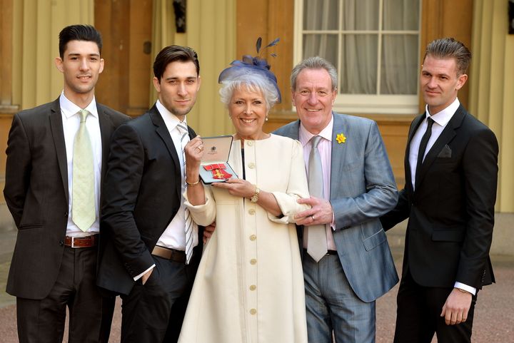 <strong>Lynda Bellingham holding her OBE with (left to right) sons Michael and Robert, husband Michael and step-son Bradley</strong>