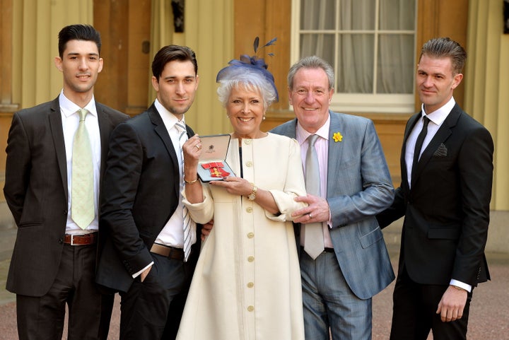 Lynda Bellingham holding her OBE with (left to right) sons Michael and Robert, husband Michael and step-son Bradley