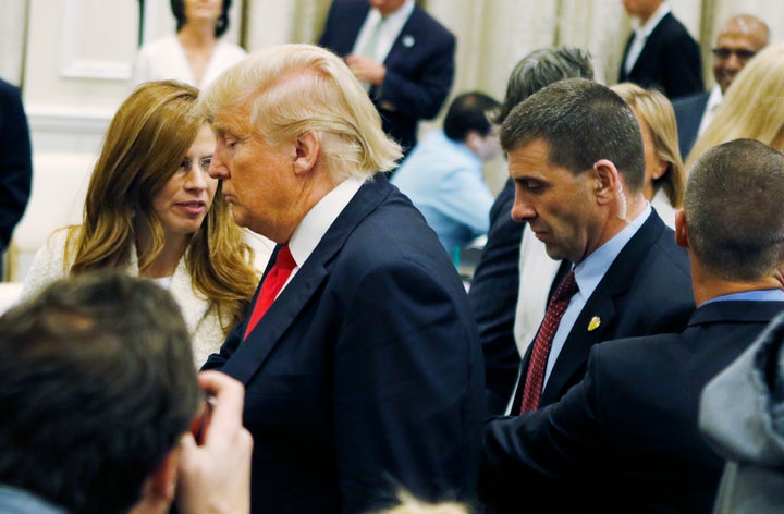 Corey Lewandowski, right, campaign manager for Donald Trump, reaches between Trump and a U.S. Secret Service agent toward Bre