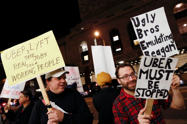 Demonstrators hold signs during a protest organized by the San Francisco Taxi Workers Alliance against ridesharing services Uber and Lyft in 2015.