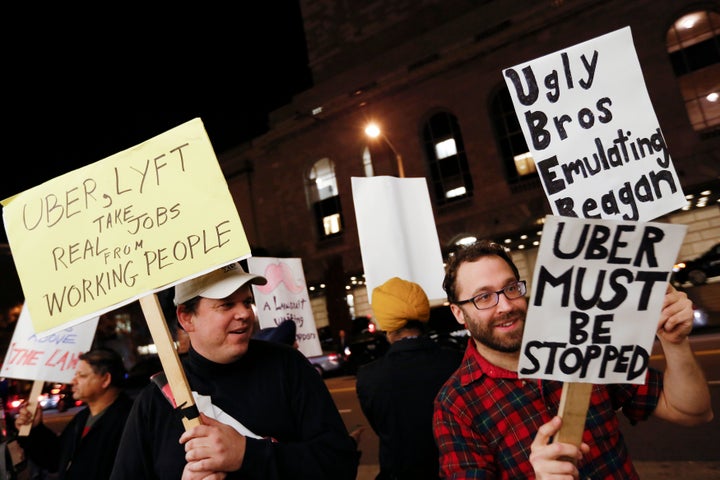 Demonstrators hold signs during a protest organized by the San Francisco Taxi Workers Alliance against ridesharing services Uber and Lyft in 2015. 