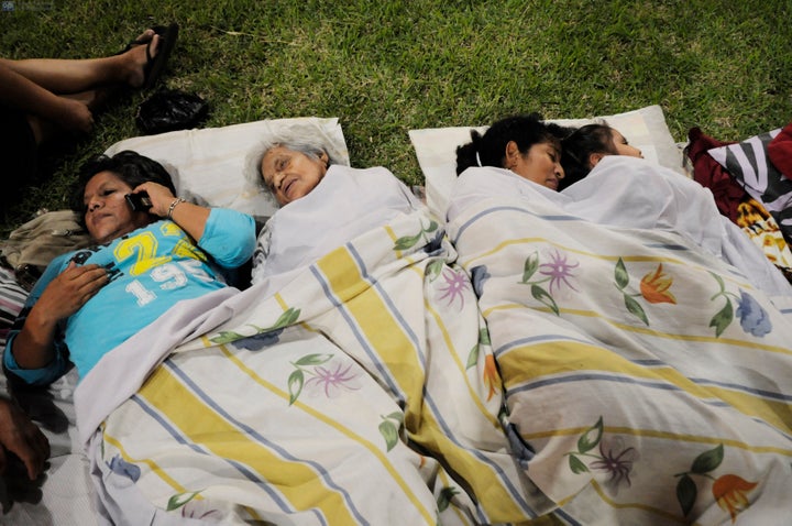 This picture shows people resting in a park after an earthquake in the city of Guayaquil on April 17, 2016.