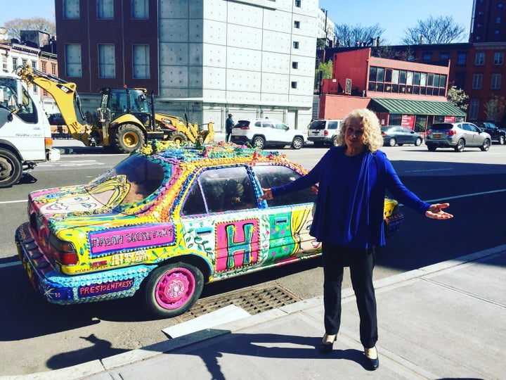 Carole King stands outside a random car parked in the West Village of New York City that is decked out in pro-Hillary Clinton messaging and artwork.