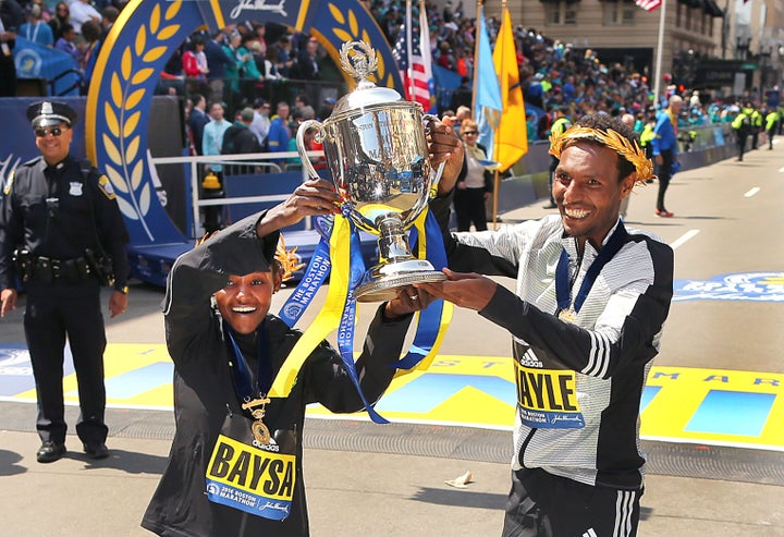 Men's winner Lemi Berhanu Hayle of Ethiopia and women's winner Atsede Baysa of Ethiopia hold up a trophy at the finish line o