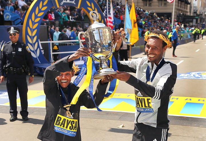 Men's winner Lemi Berhanu Hayle of Ethiopia and women's winner Atsede Baysa of Ethiopia hold up a trophy at the finish line of the 120th Boston Marathon on Monday, April 18, 2016.