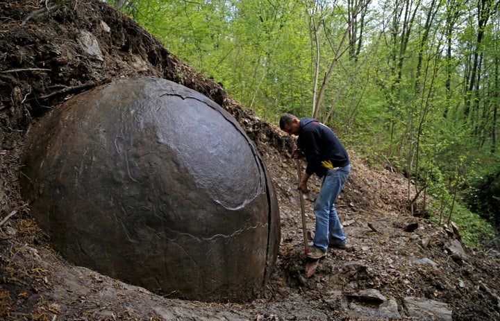 Suad Keserovic cleans a stone ball in Podubravlje village near Zavidovici, Bosnia and Herzegovina, April 11, 2016. Keserovic claimed that the stone sphere is 3.30 meters in diameter and the estimated weight of it is about 35 tons. Hundreds of tourists from around the world have visited this stone.