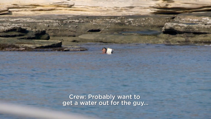 A man, said to have been castaway on an island for more than two days, is seen swimming out to a passing camera crew.