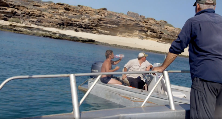 The castaway is seen drinking a bottle of water after being taken onboard the film crew's boat.