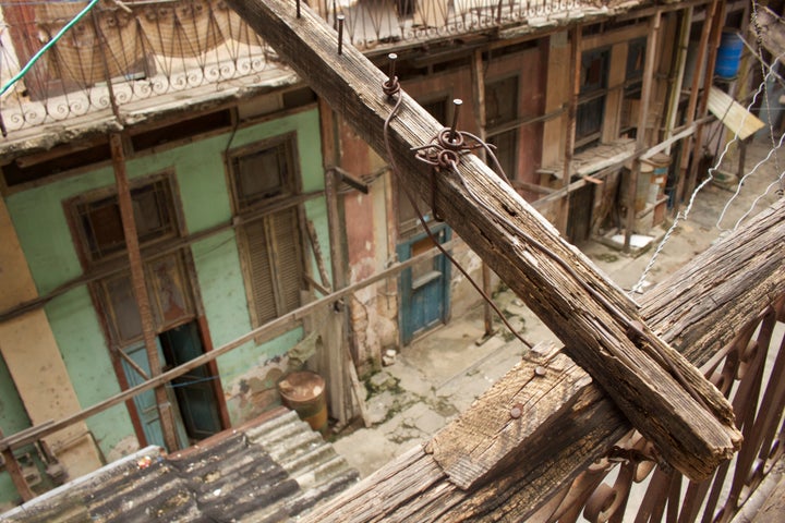 A splintering four-by-four supports the second-floor balcony in Francisco Jesús Jiménez's dilapidated apartment building. Of all the changes he's experienced since being deported back to Cuba, he cites housing as one of the most difficult.