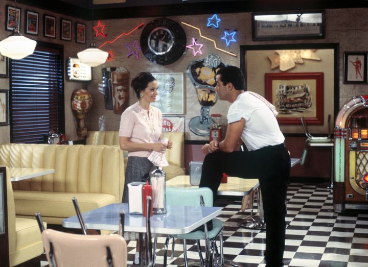 Courteney Cox as Monica Geller and Carlos Gomez as Julio in "Friends."