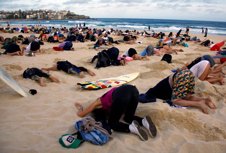 Australians stick their heads in the sand in protest of the government's climate policies in 2014.