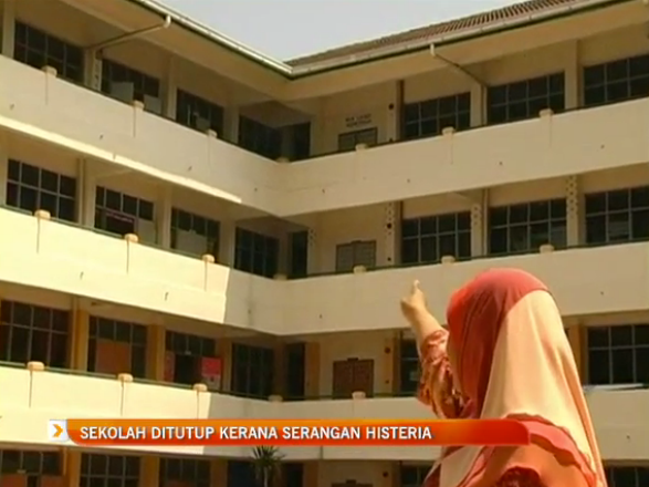 A staff member gestures at the area of the school where the incidents occurred