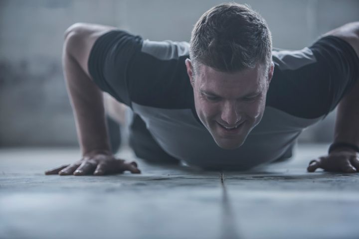 Caucasian athlete doing push-ups on floor Getty Images