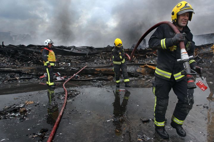 Firefighters work to clear the wreckage at Sony's distribution centre