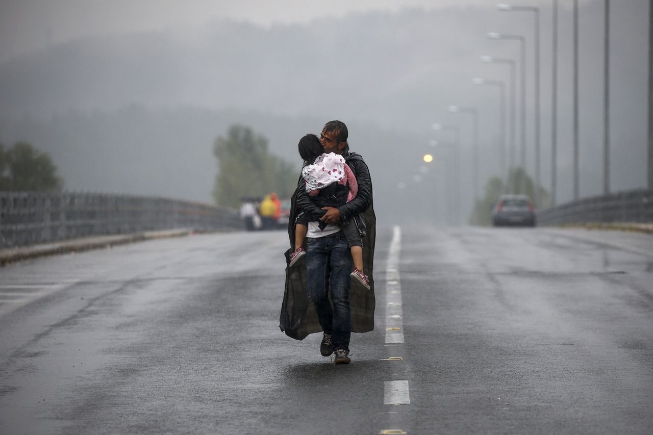 Photographers working for Reuters and the New York Times won a Pulitzer Prize for their coverage of the refugee crisis in Greece. This photo by Yannis Behrakis shows a Syrian refugee kissing his daughter as he walks to the Greece-Macedonia border.