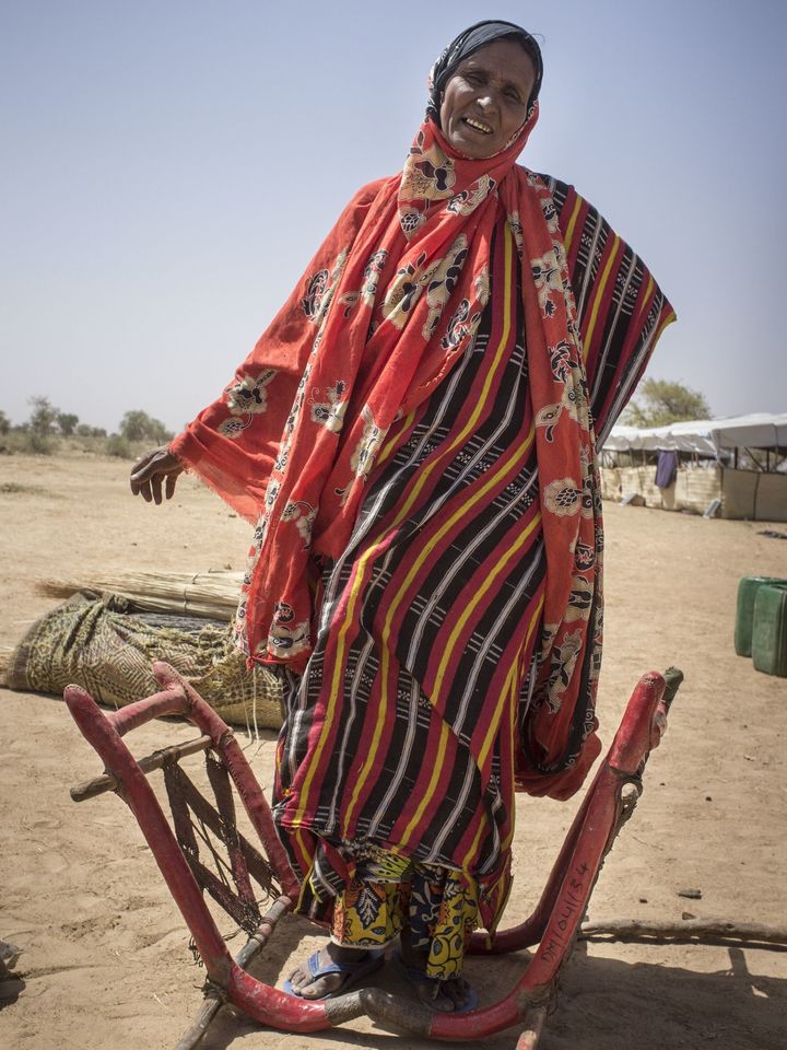 A Tuareg woman from Timbuktu stands next to the livestock chair she rode upon to reach Burkina Faso. She fled Mali by camel in 2013.