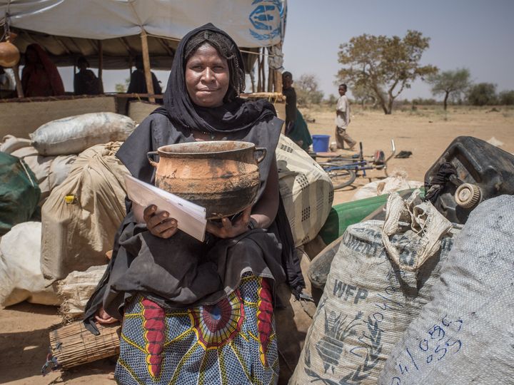 This woman traveled from Gossi, Mali, to Damba refugee camp on the Mali-Burkina Faso border in 2013. She holds up her most valued possession: a cooking pot.
