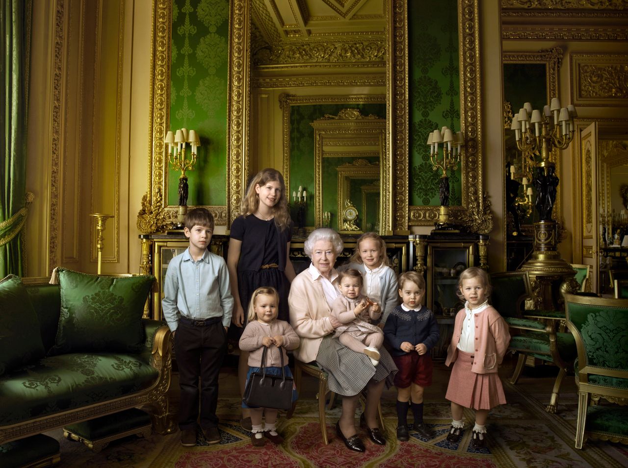 This official photograph, released by Buckingham Palace to mark her 90th birthday, shows Queen Elizabeth II with her five great-grandchildren and her two youngest grandchildren in the Green Drawing Room, part of Windsor Castle's semi-State apartments. The children are: James, Viscount Severn (left), 8, and Lady Louise (second left), 12, the children of The Earl and Countess of Wessex; Mia Tindall (holding The Queen's handbag), the two year-old-daughter of Zara and Mike Tindall; Savannah (third right), 5, and Isla Phillips (right), 3, daughters of The Queen's eldest grandson Peter Phillips and his wife Autumn; Prince George (second right), 2, and in The Queen's arms and in the tradition of Royal portraiture, the youngest great-grandchild, Princess Charlotte (11 months), children of The Duke and Duchess of Cambridge.