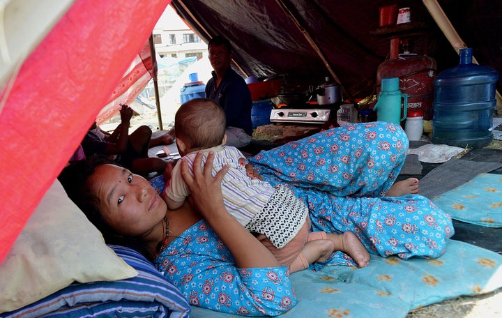 Nepalese residents lie in a temporary shelter at a relief camp for earthquake survivors in Kathmandu on May 21, 2015, after multiple earthquakes struck the Himalayan nation. Nearly 8,500 people have now been confirmed dead in the disasters, which destroyed more than half a million homes and left huge numbers of people without shelter with just weeks to go until the monsoon rains. AFP PHOTO/ISHARA S. KODIKARA (Photo credit should read Ishara S.KODIKARA/AFP/Getty Images)