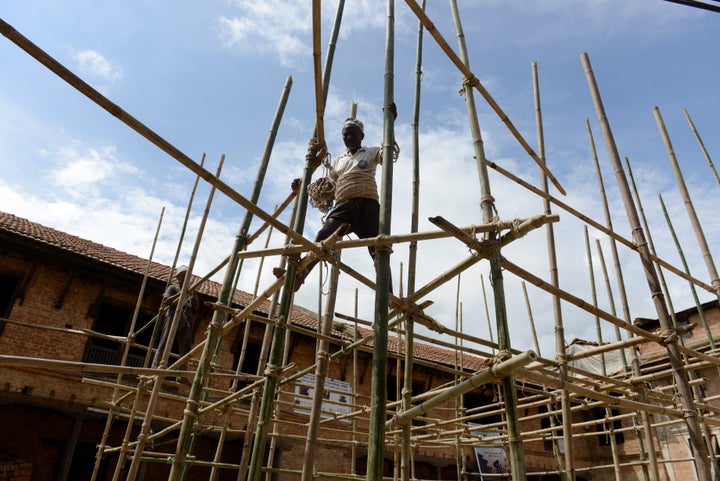 A Nepalese labourer works on bamboo scaffolding during repairs to a temple damaged in an earthquake at the village of Khokana, on the outskirts of Kathmandu on August 14, 2015. Twin earthquakes which struck the Himalayan nation in April and May, killed more than 8,800 people, destroyed nearly half a million houses and damaged another 280,000, leaving thousands in need of food, clean water and shelter. AFP PHOTO / Prakash MATHEMA (Photo credit should read PRAKASH MATHEMA/AFP/Getty Images)