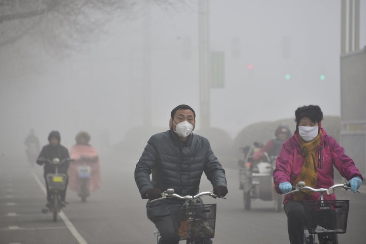 People ride their bikes in heavy smog on Feb.12, 2015 in Liaocheng, China.