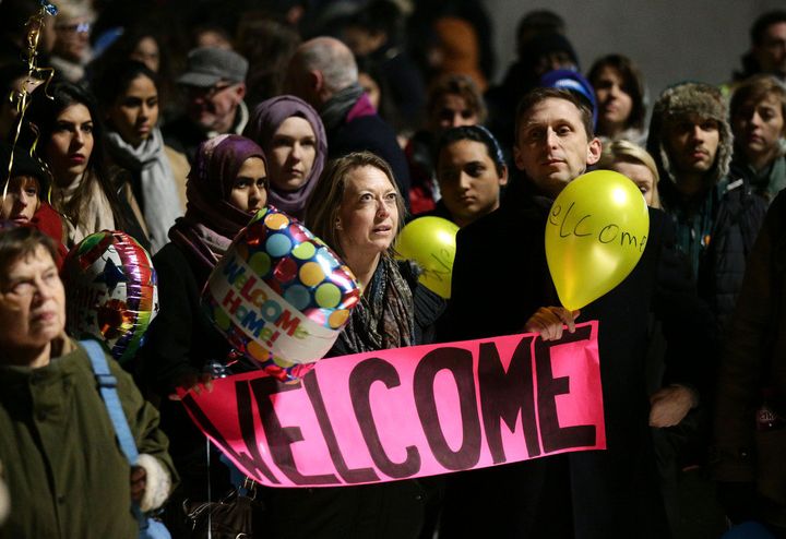 A group of Brits wait at King's Cross Station in London to welcome Syrian refugees to the country