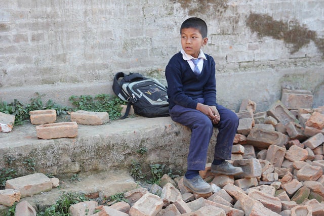 A boy sits in the rubble of a school in Bhaktapur, Nepal. Global children's charity Theirworld released a video this week that shows how many children in Nepal struggle to get to school one year after deadly earthquakes hit the country. 