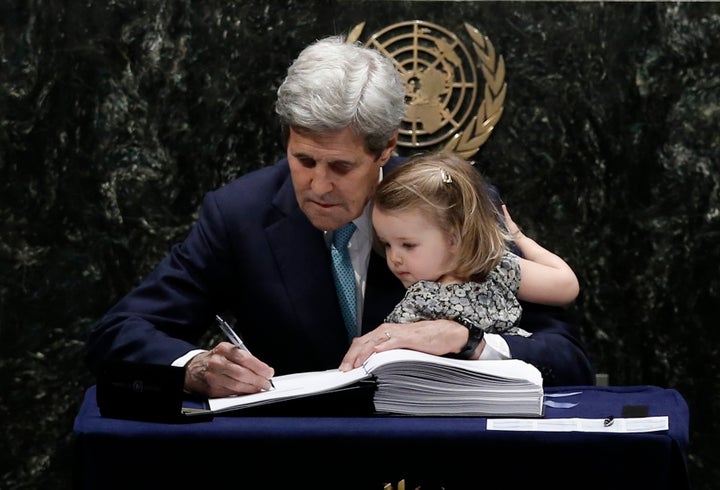 U.S. Secretary of State John Kerry holds his 2-year-old granddaughter as he signs the Paris agreement on climate change, April 22, 2016.