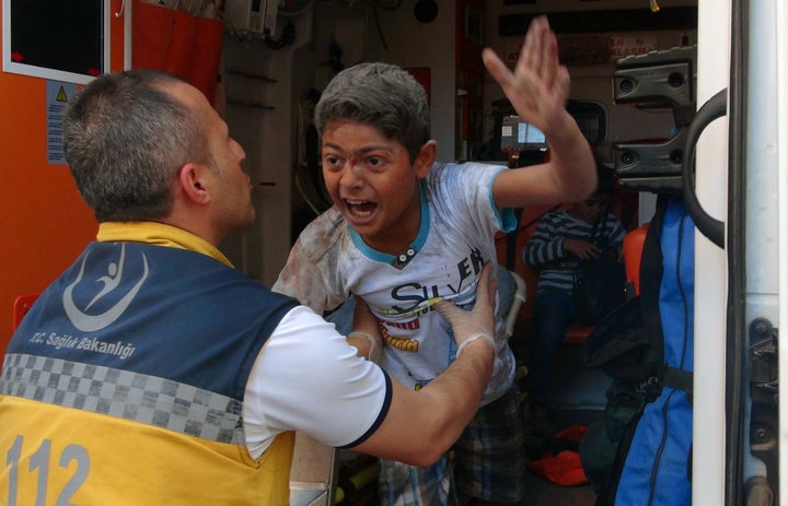 Rescue workers help a boy injured by an ISIS rocket in Kilis on April 18. Four Syrians were killed after five rockets fi