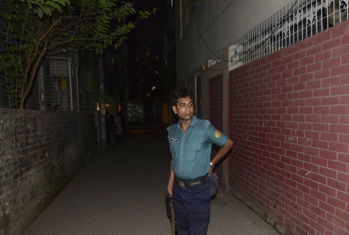 A Bangladeshi police official stands in front of the apartment in Dhaka where Xulhaz Mannan was killed. 