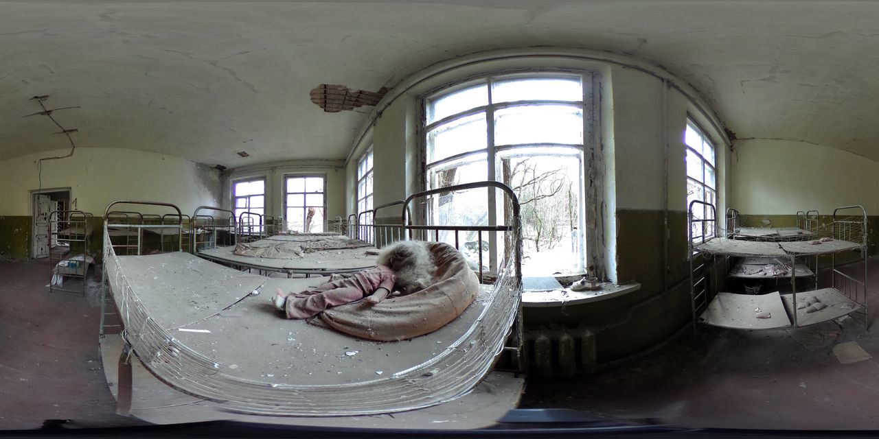 A blackened doll lies on a bed in an abandoned kindergarten.