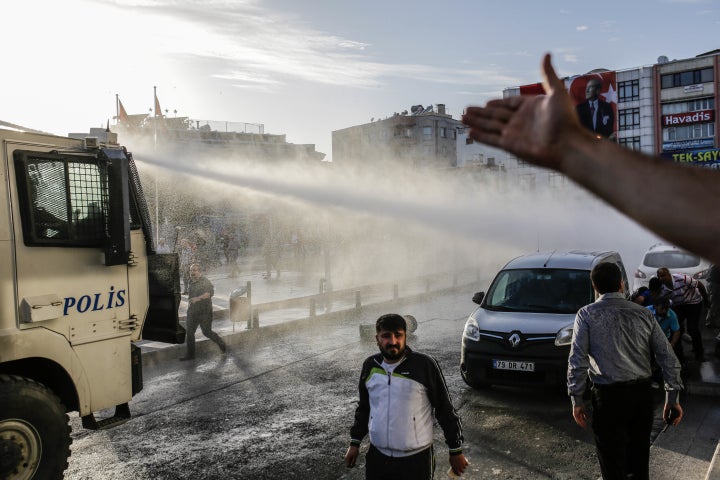 Turkish anti-riot police use water cannon to disperse people who gathered after a rocket hit a mosque on April 24 in Kilis, T