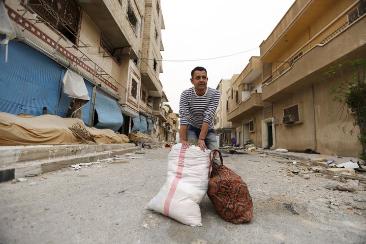 This security permit regulation was imposed so that the government could keep tighter control over an increasing population and to determine the allegiances of new arrivals. A man collects his belongings from his damaged house in Palmyra.