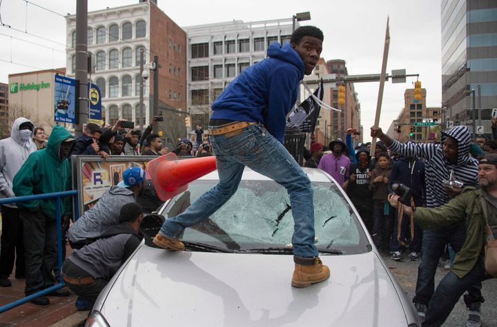 Allen Bullock looks back at the camera as demonstrators destroy the windshield of a Baltimore Police car on April 25, 2015.