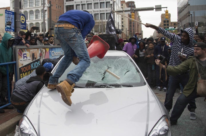 Bullock and other demonstrators smash a Baltimore Police car as they protest the death of Freddie Gray.