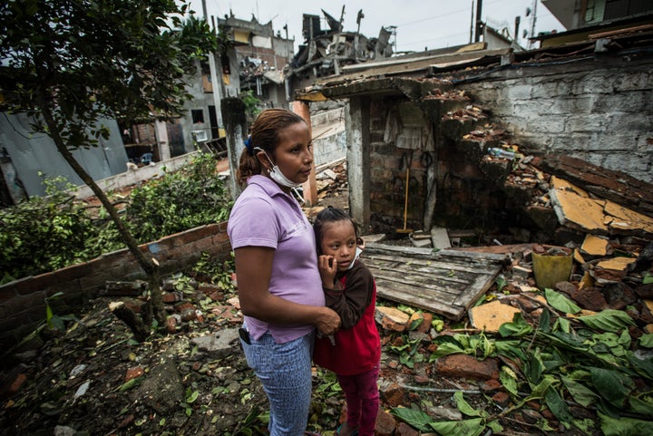 A woman and her daughter visit with neighbors in an area severely damaged by an earthquake in Pedernales, Ecuador.