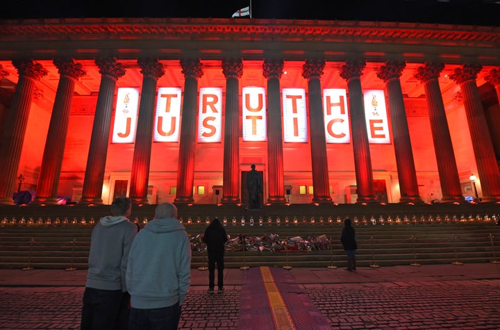 Liverpool's St Georges Hall is lit up Red adorned with a banner reading 'Truth and Justice'