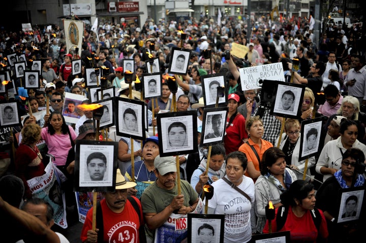 Protesters march in Mexico City on April 26, 2016, carrying the portraits of the 43 students who have been missing since September 2014. The government's investigation of the case has been plagued by allegations of torture and disregard for physical evidence.