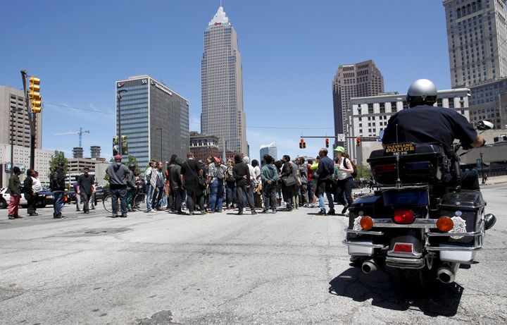 Protesters gather at a downtown intersection as a Cleveland Police officer looks on following a not guilty verdict for Cleveland police officer Michael Brelo on manslaughter charges, in Cleveland on May 23, 2015.