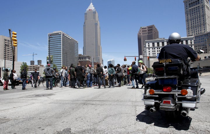 Protesters gather at a downtown intersection as a Cleveland Police officer looks on following a not guilty verdict for Cleveland police officer Michael Brelo on manslaughter charges, in Cleveland on May 23, 2015.